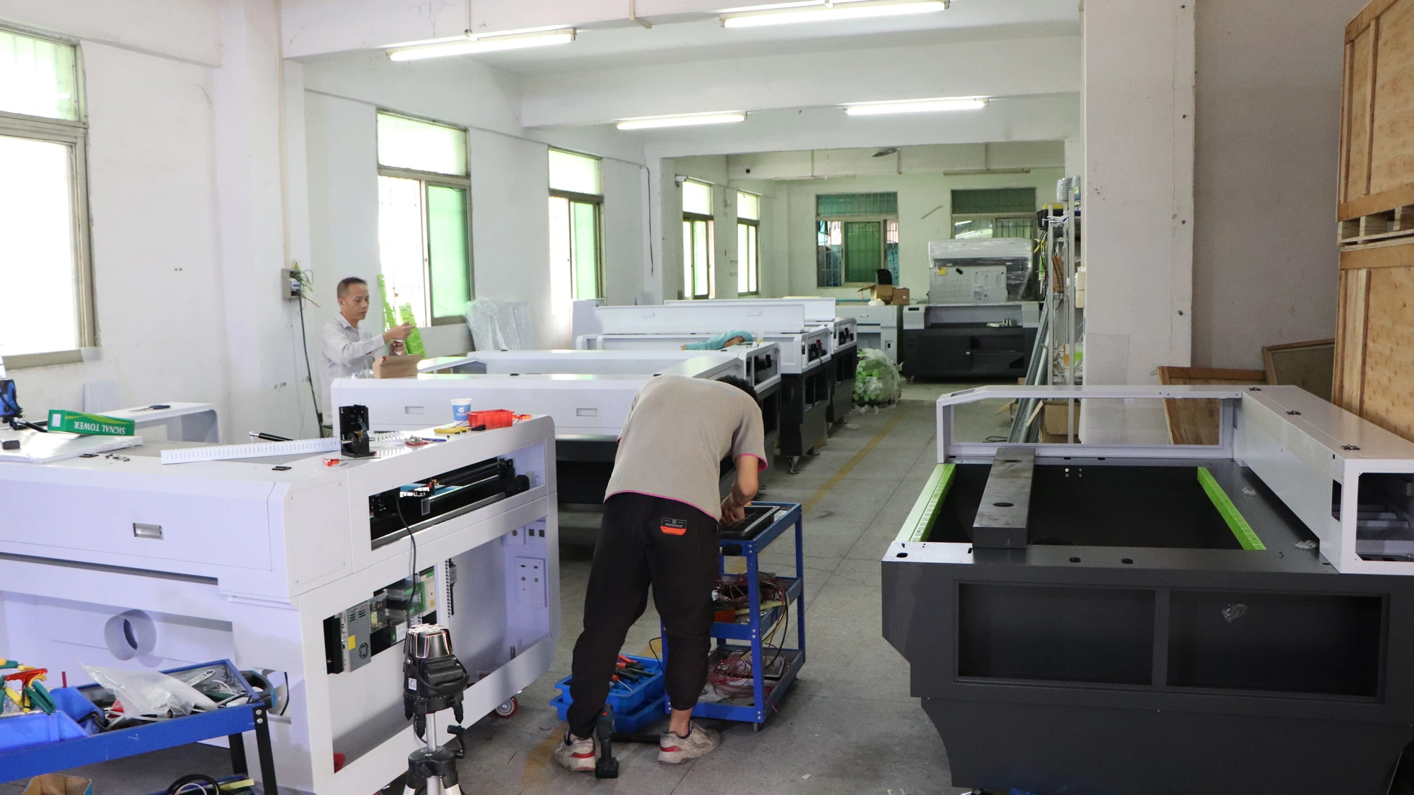 Technicians assembling CO2 laser equipment in a workshop
