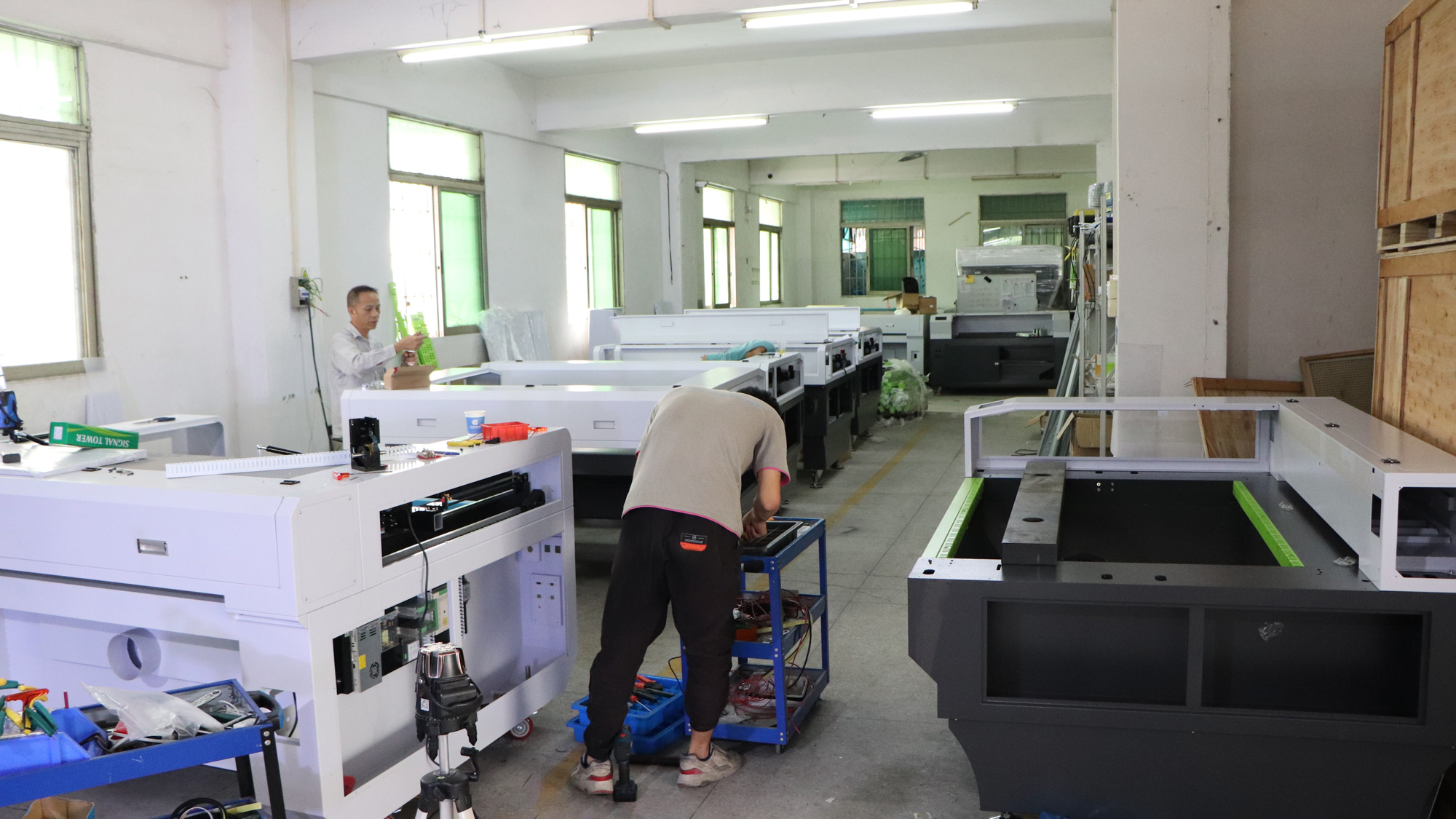 Technicians assembling CO2 laser equipment in a workshop